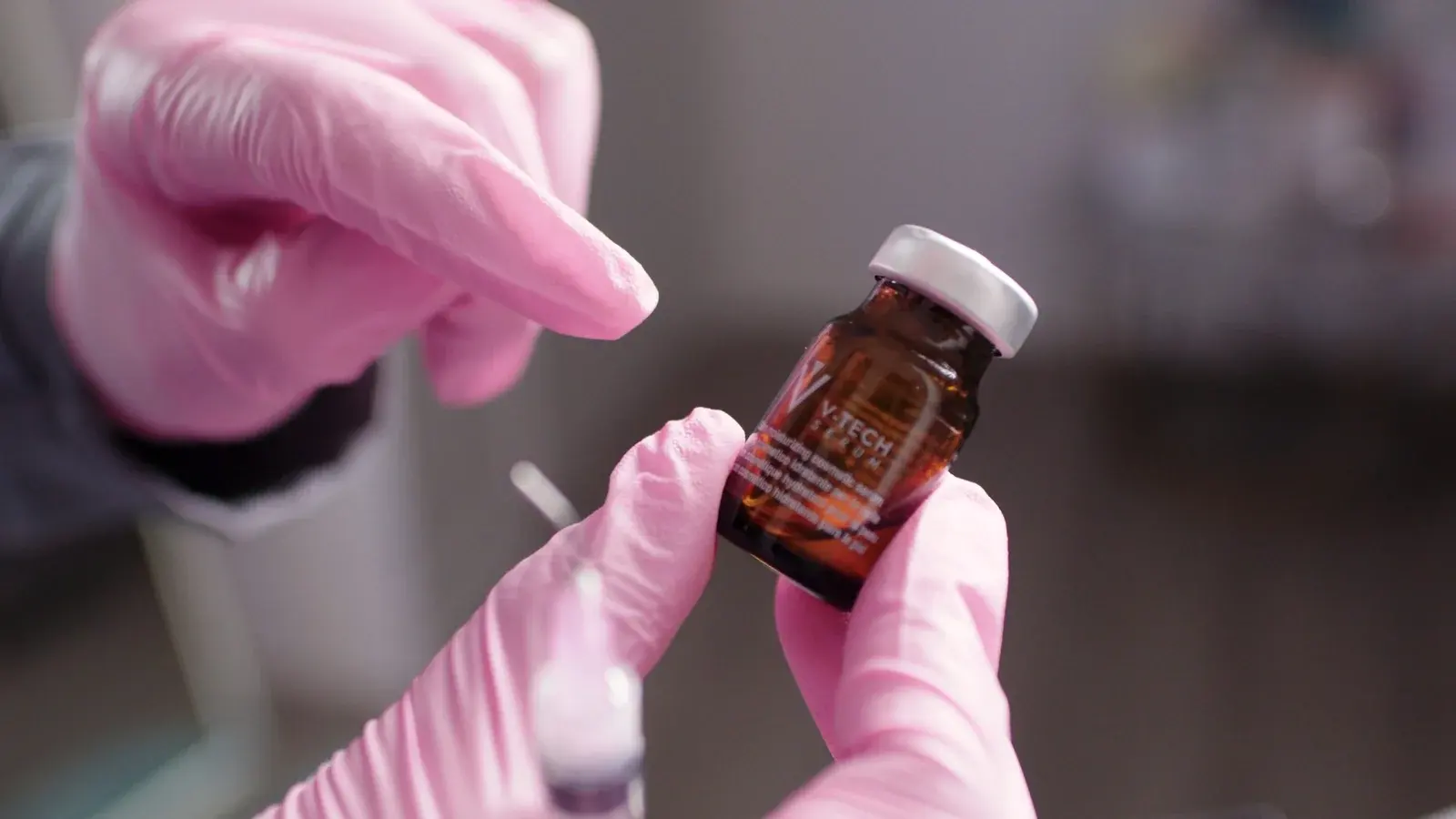 Personal clínico de Golden Rose con guantes preparando un vial de suero para un tratamiento