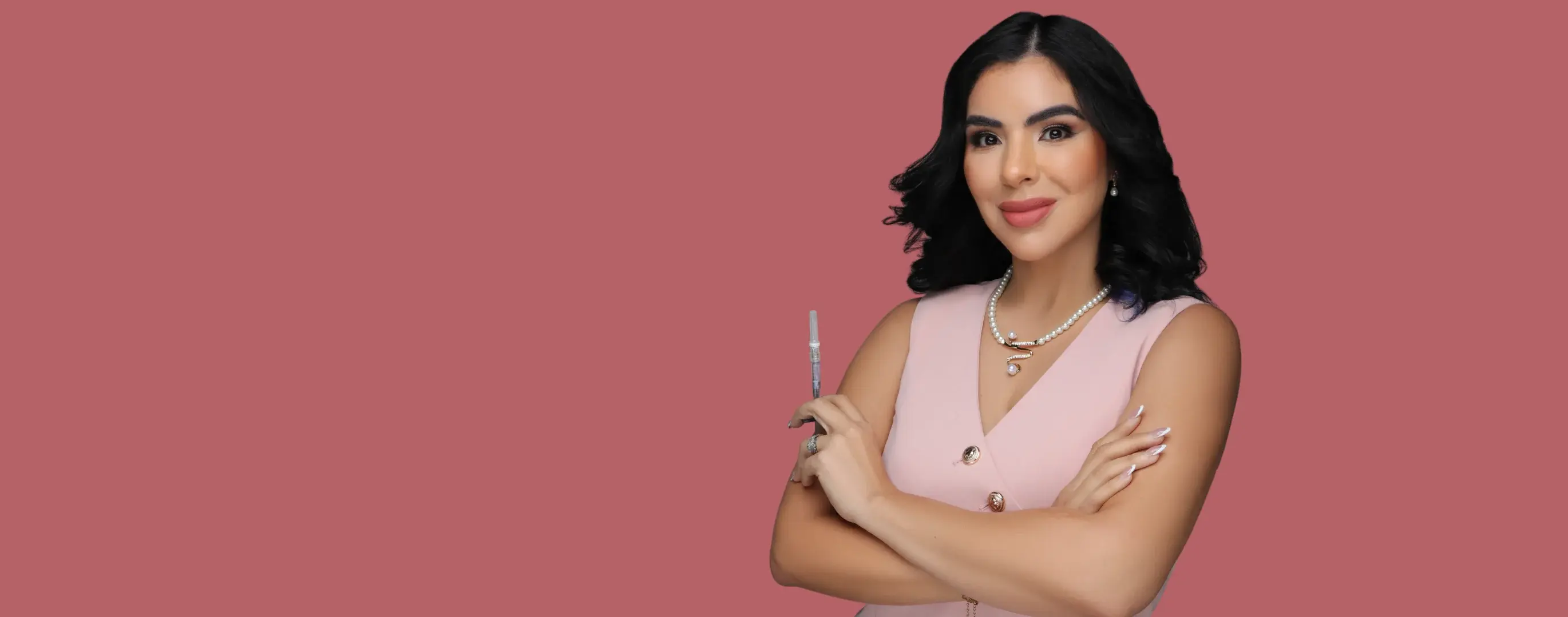Dr. Kimberly Ayala Vega holding an injection syringe against a rose backdrop