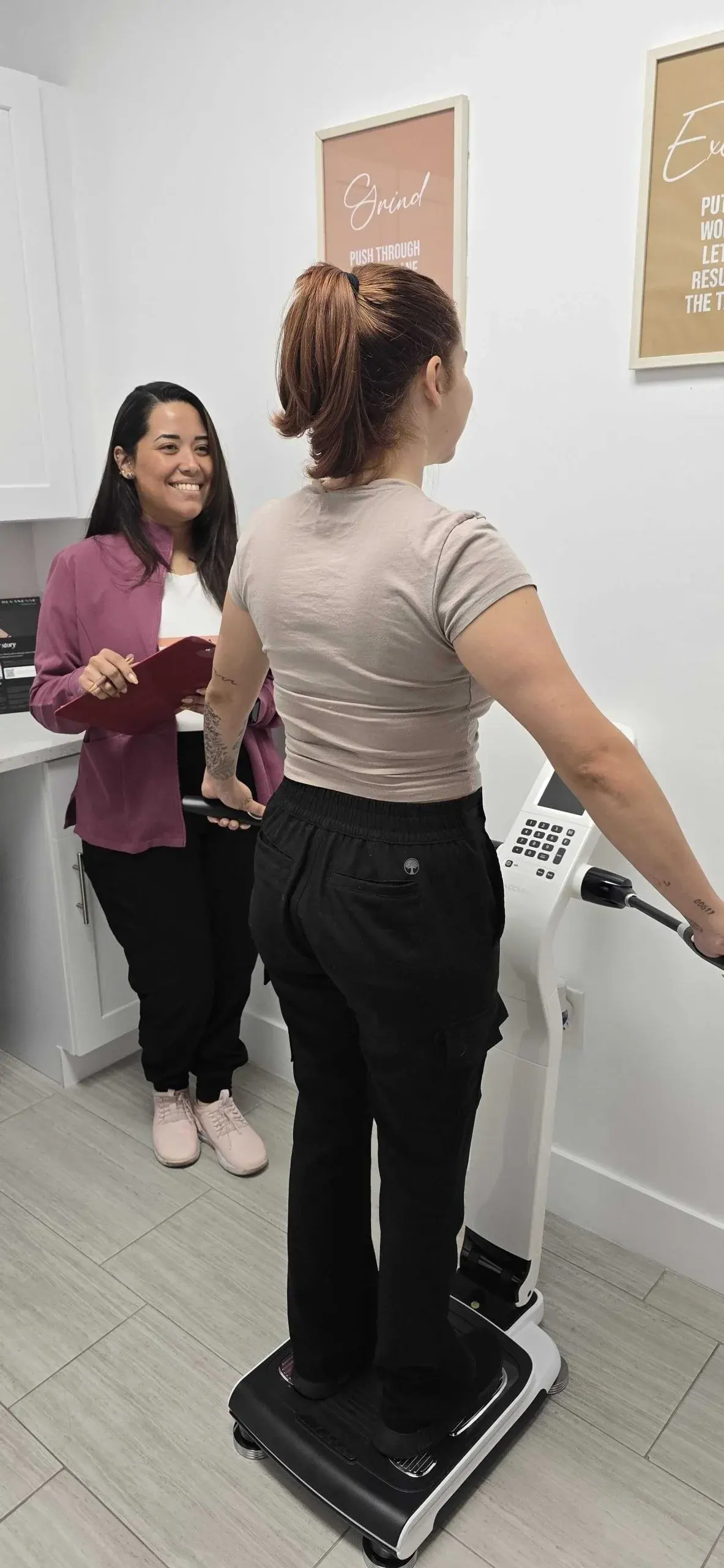 A Golden Rose patient on the body composition scale while Dr. Ayala reviews her goals